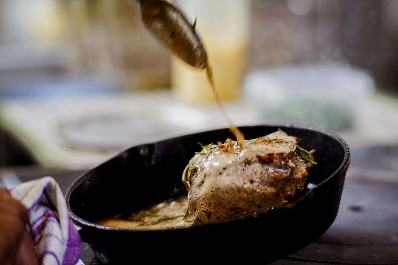 Parehua Resort Martinborough Bagian luar foto A chef pouring sauce over a steak